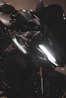 Close-up of a waterproof electric motorcycle's glossy body shining under streetlights