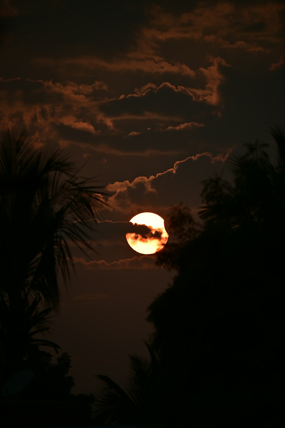 Le soleil se couche derrière les nuages dans le ciel