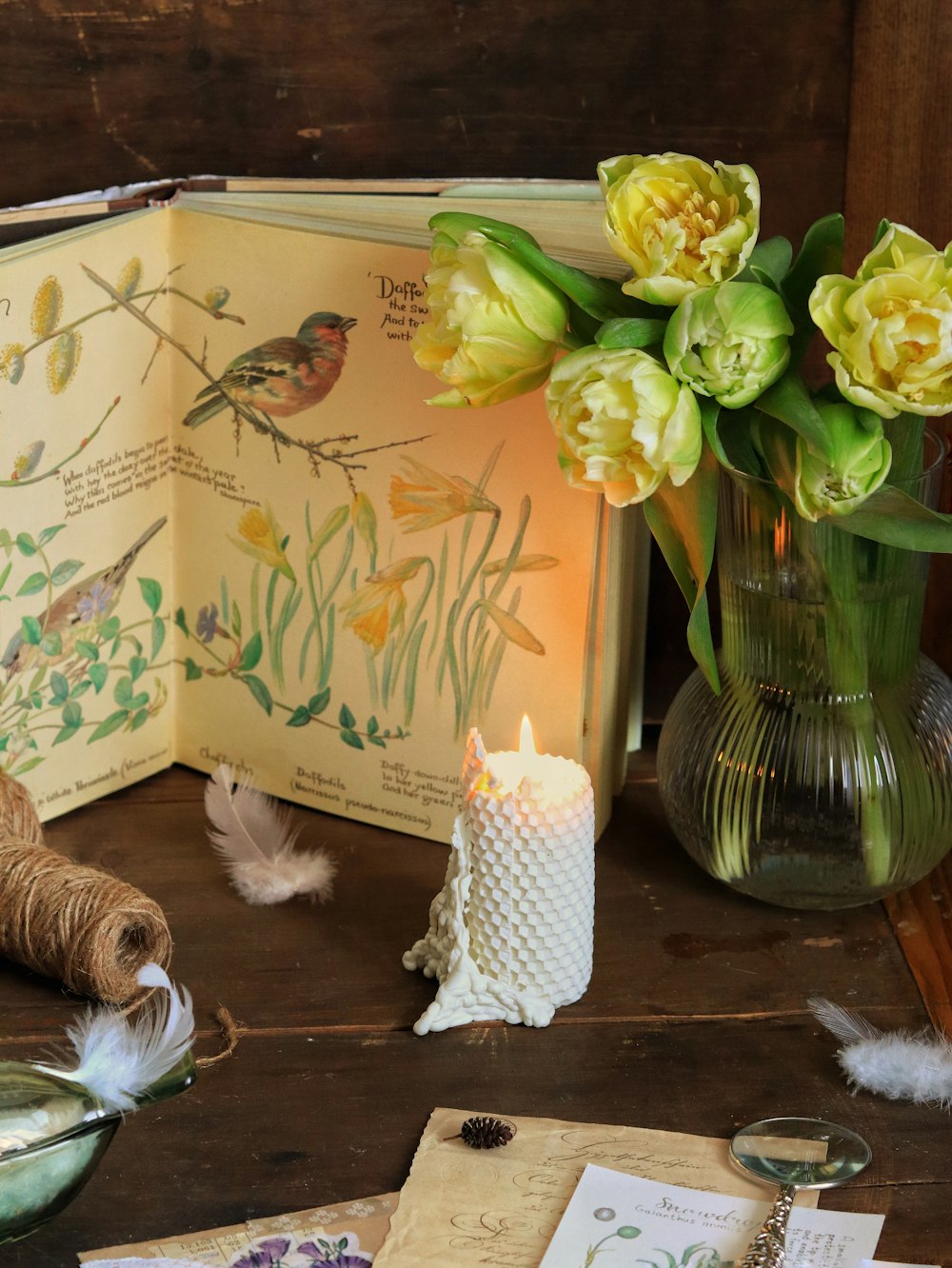 a table topped with a vase filled with yellow flowers