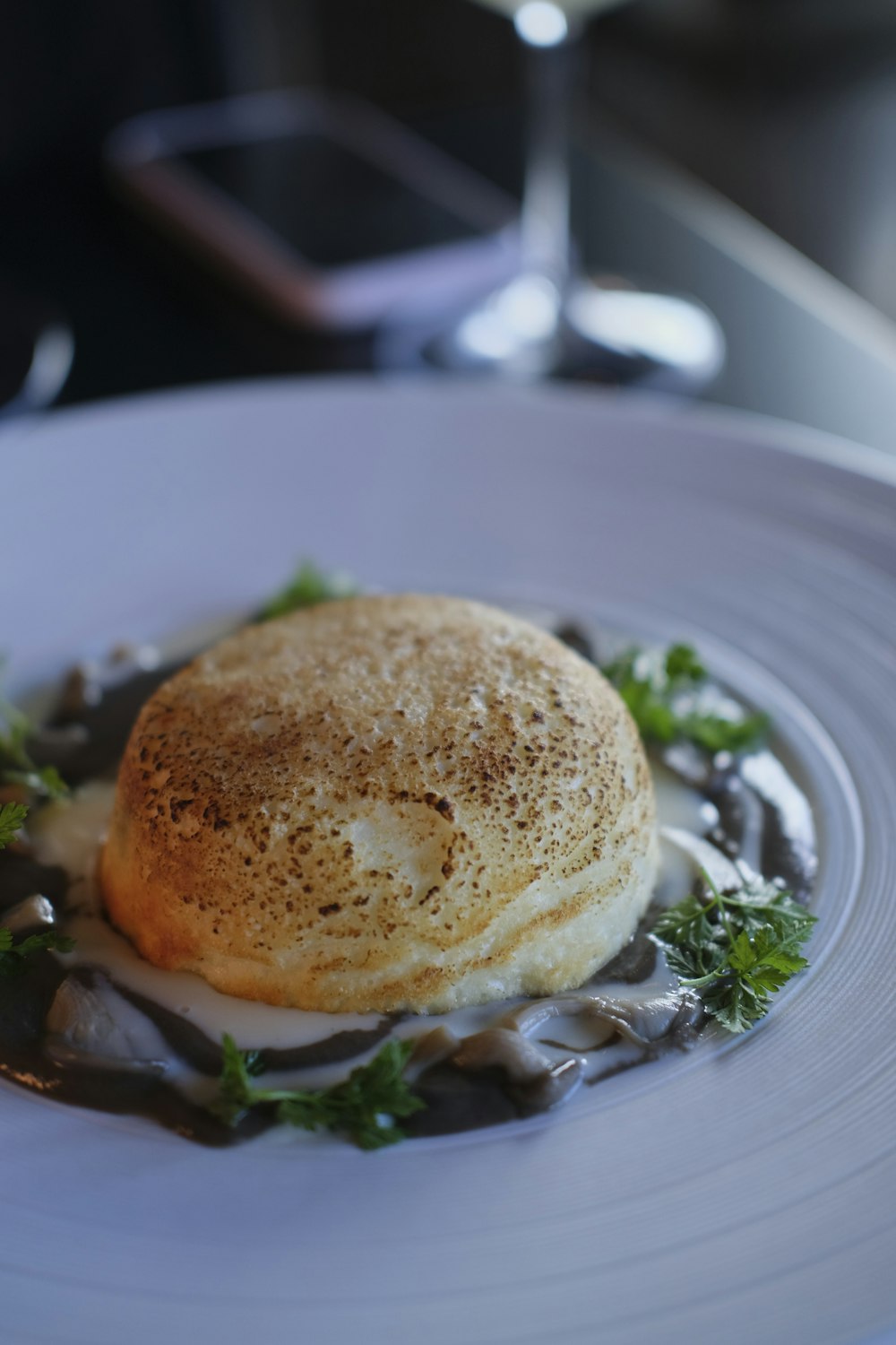 a white plate topped with food and a glass of wine