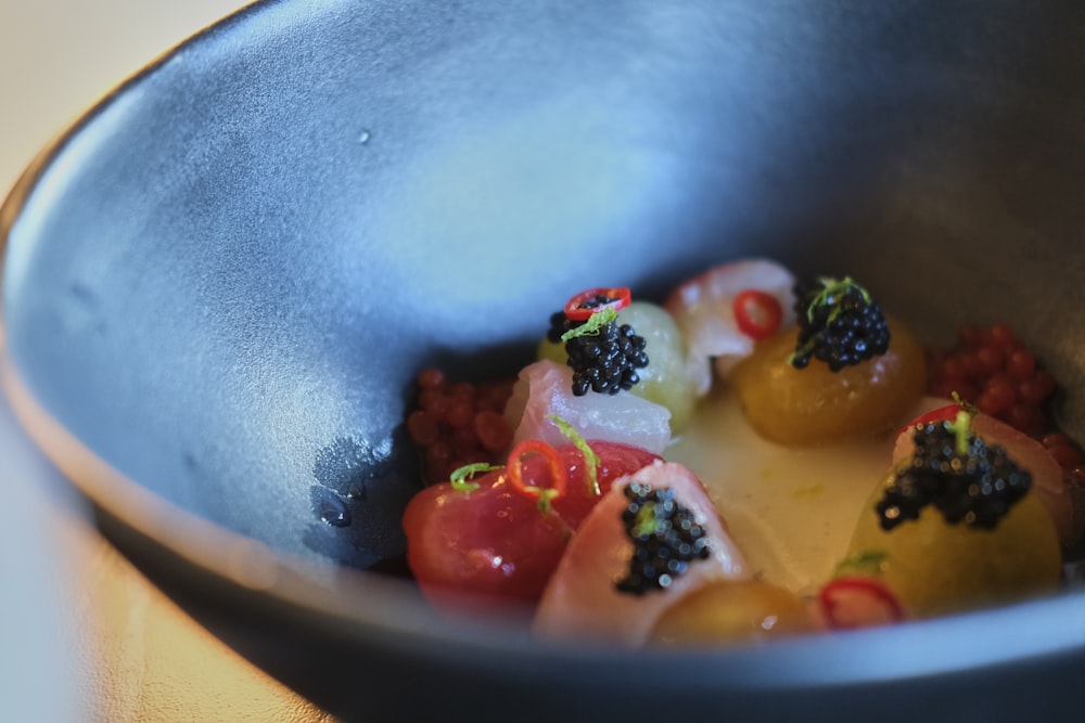 a metal bowl filled with food on top of a table