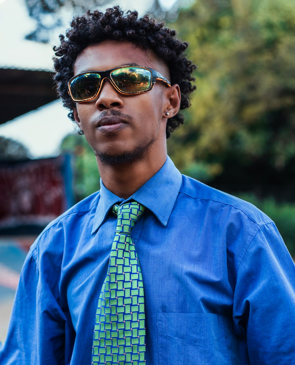Foto Un con camisa azul y corbata verde – Imagen Gafas de sol gratis en