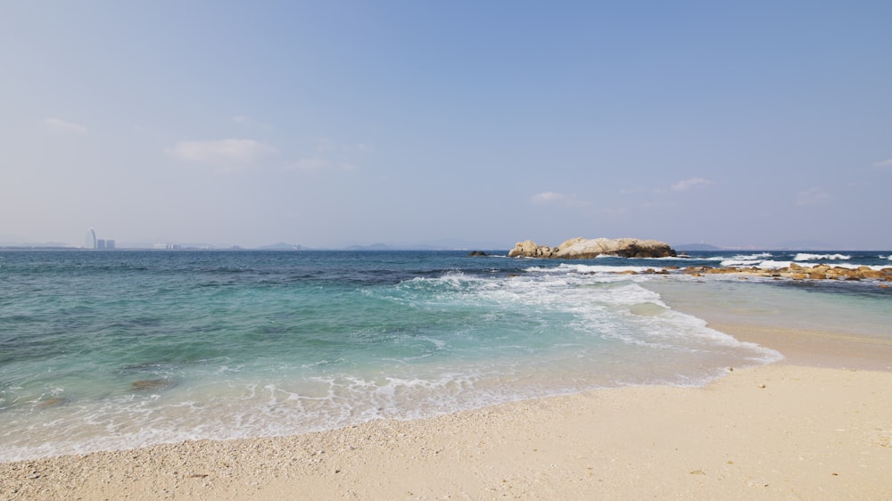 a sandy beach with waves coming in to shore