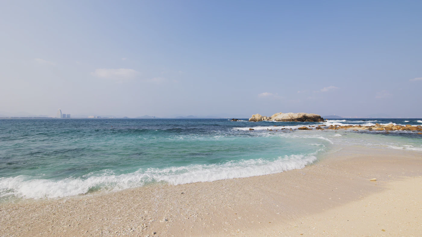 Gentle waves washing over a sandy beach on Hainan island