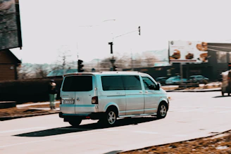 A cargo van maneuvering through city streets with buildings in the background