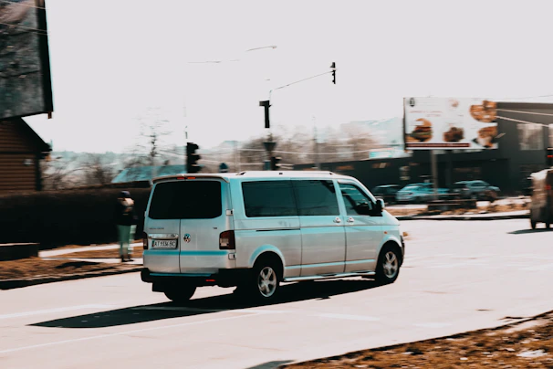 A cargo van maneuvering through city streets with buildings in the background