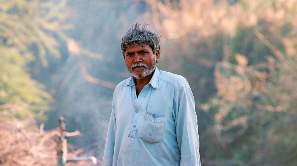 a man standing in front of a forest