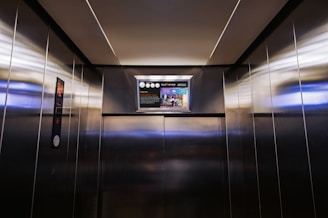 a metallic elevator with a poster on the wall