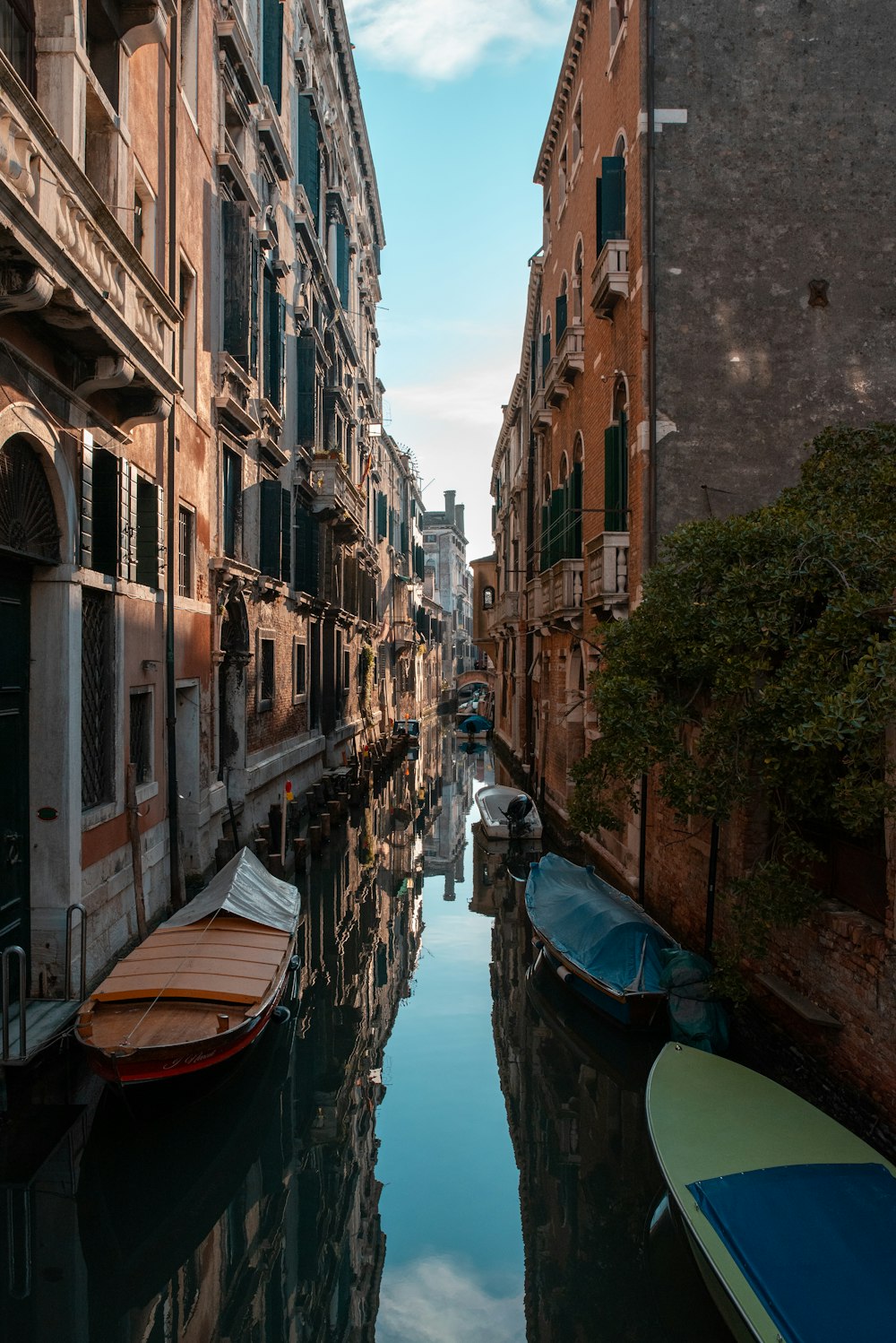 a narrow canal with several boats in it