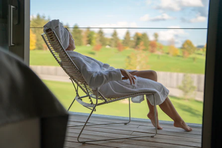 a woman sitting in a chair looking out a window