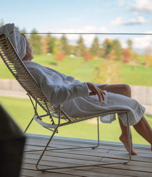 a woman sitting in a chair looking out a window