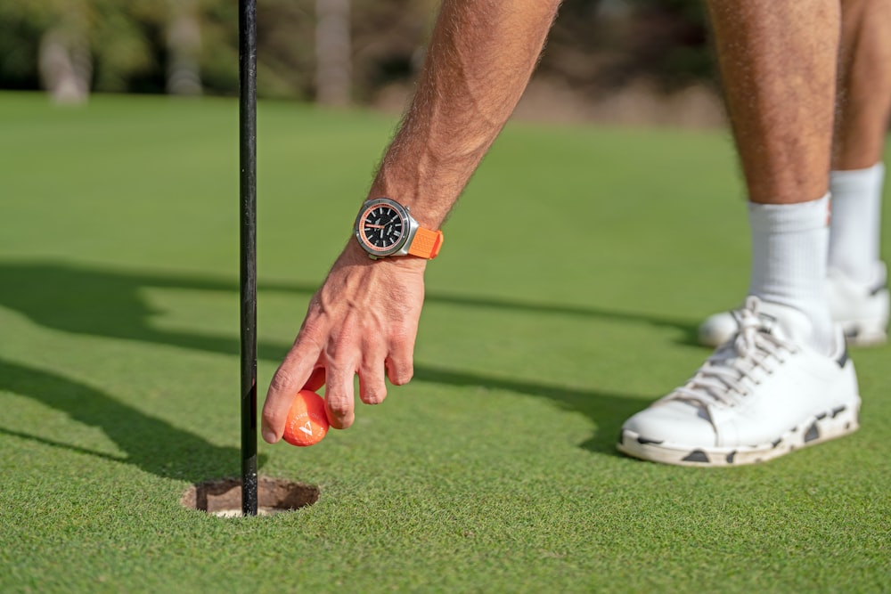 um homem colocando um putt em um campo de golfe