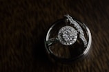 Close-up of wedding rings resting on a dark textured surface.