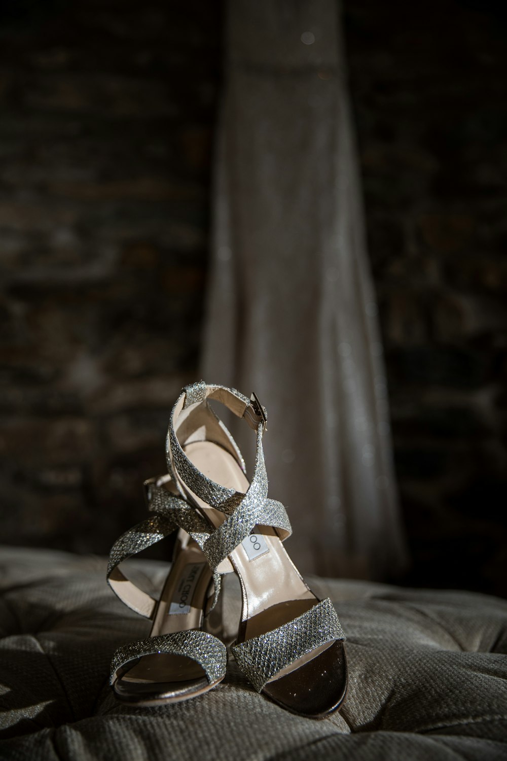 a pair of high heeled shoes sitting on top of a bed