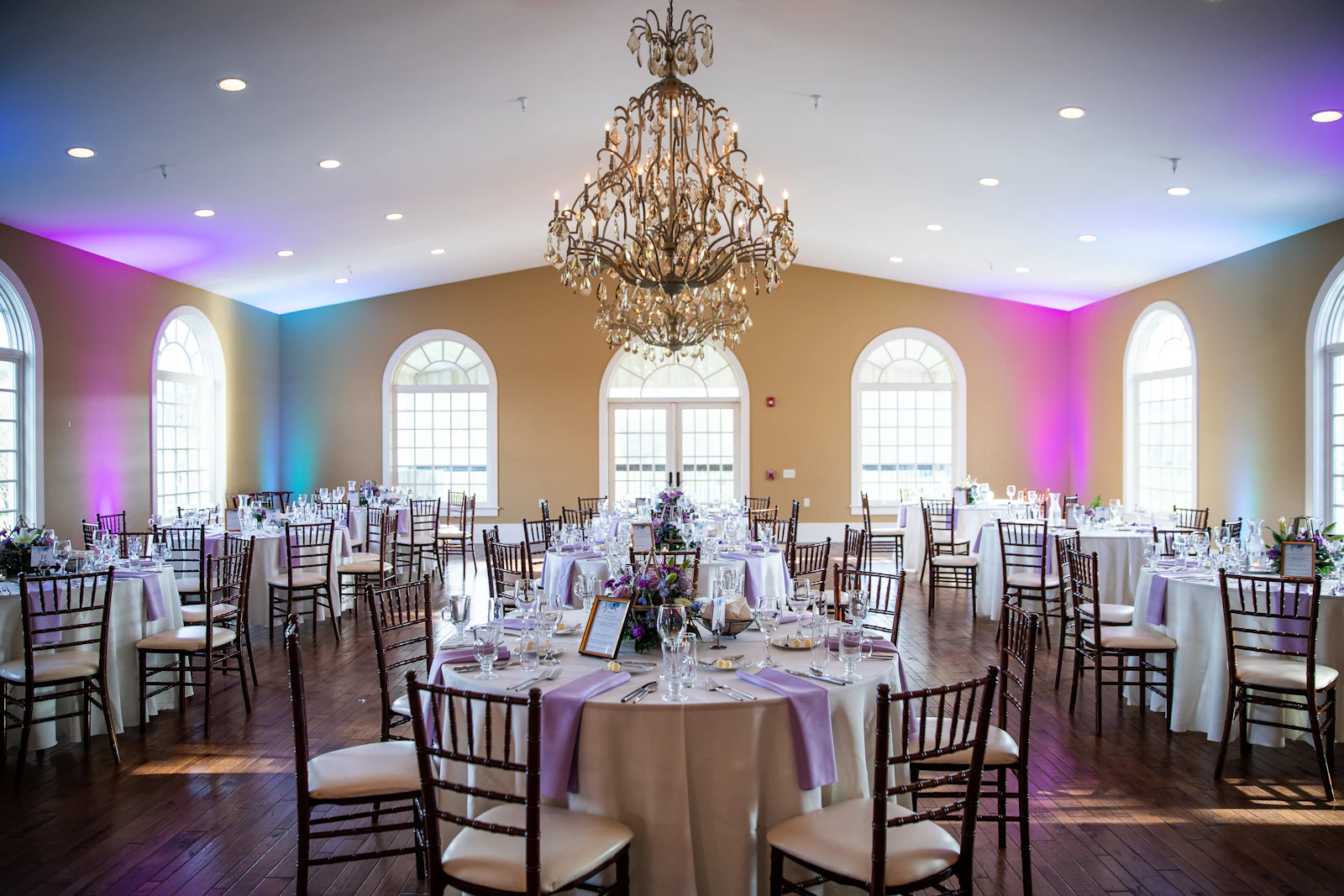 Banquet room with a chandelier and laid tables