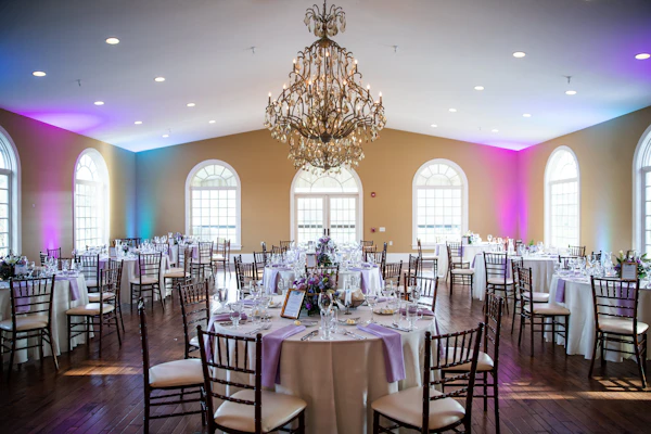 Salón de banquete con candelabro y mesas decoradas