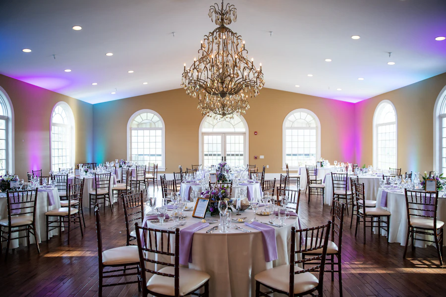 Salón de eventos elegante con candelabro y mesas montadas
