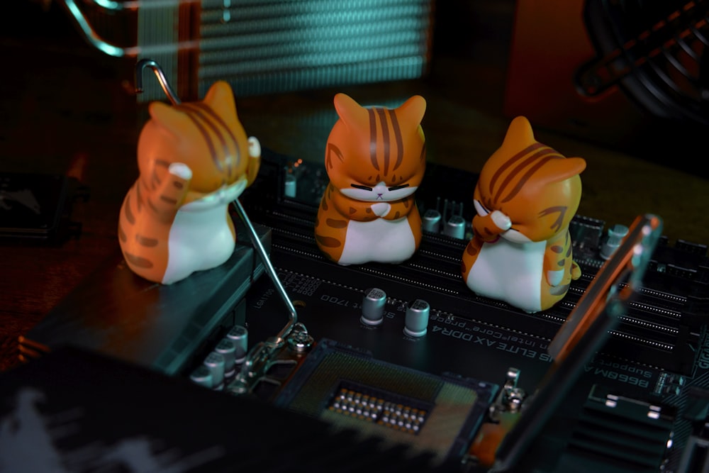 a close up of a computer motherboard with three cats on it