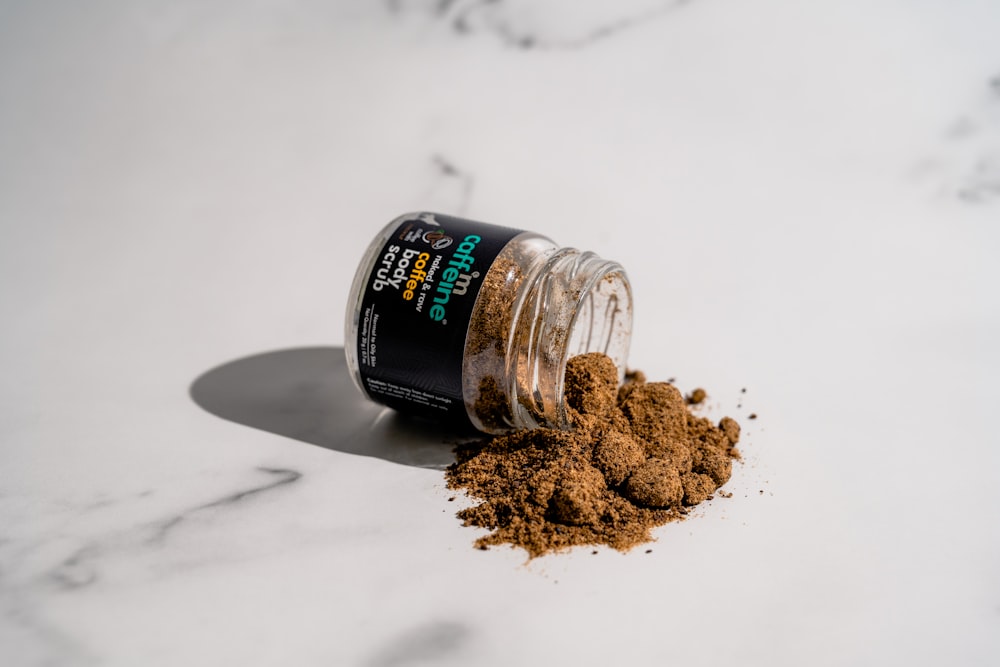 a jar filled with dirt sitting on top of a white counter