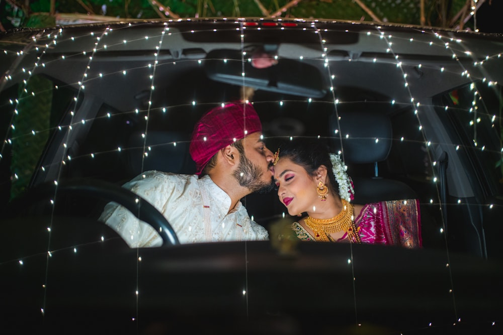 a bride and groom kissing in a car