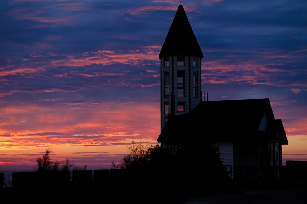 a church steeple with a sunset in the background