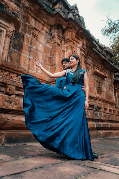 a woman in a blue dress standing next to a man