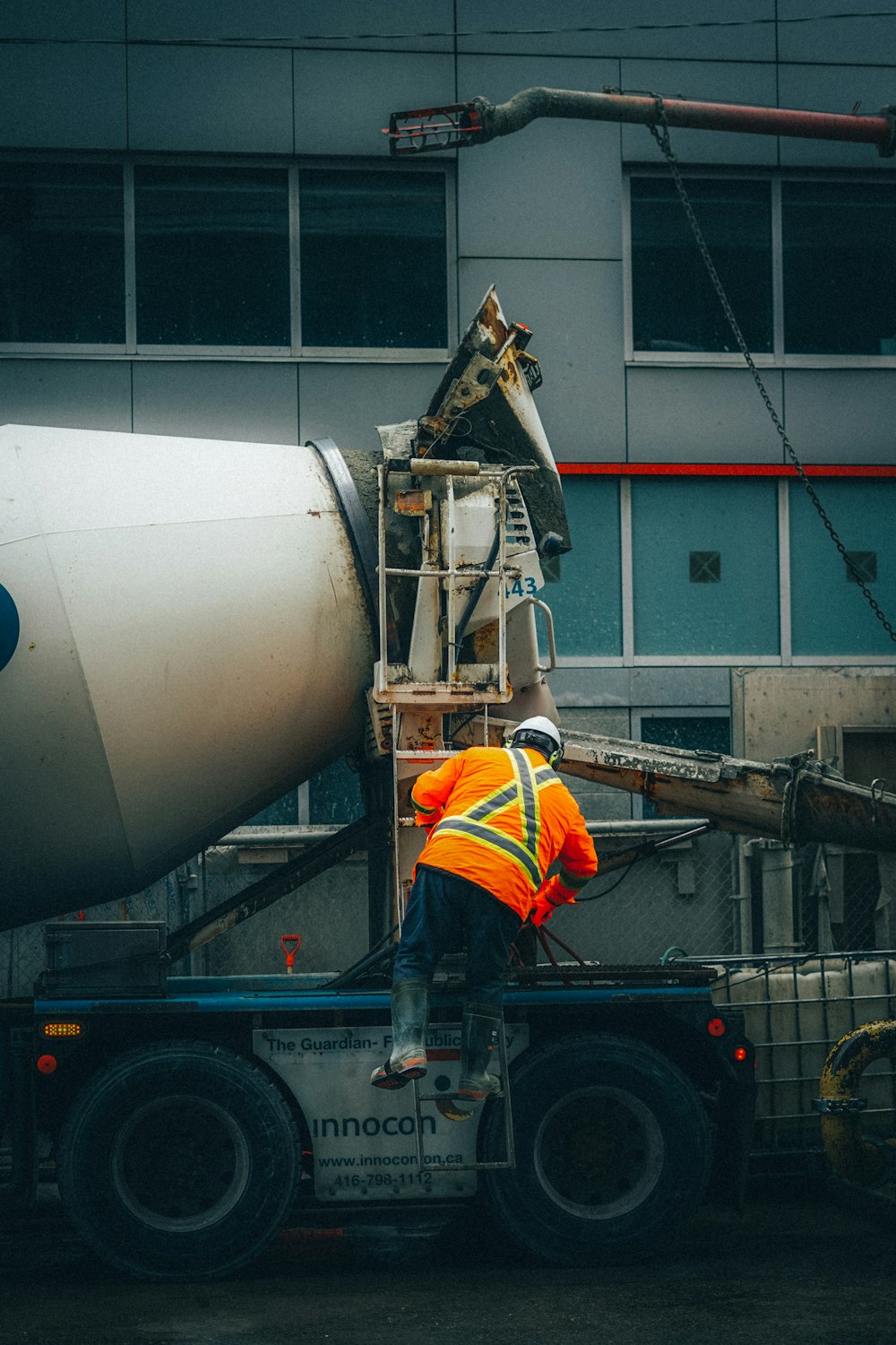 a man in an orange safety vest working on a jet