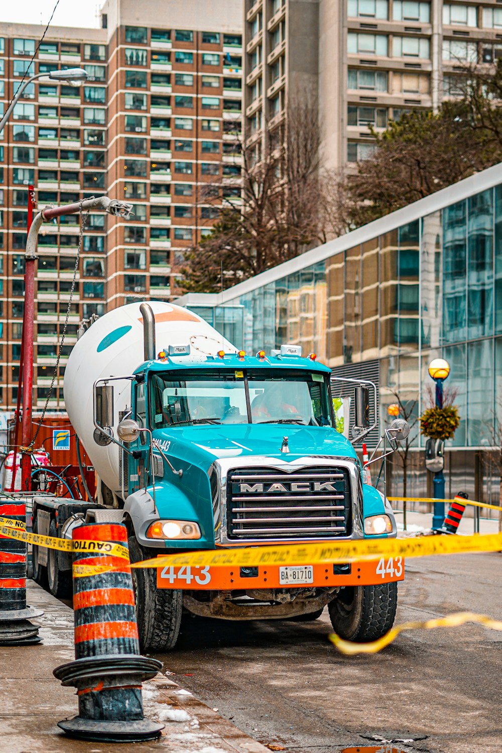 un camion de ciment stationné à côté d’un cône de construction
