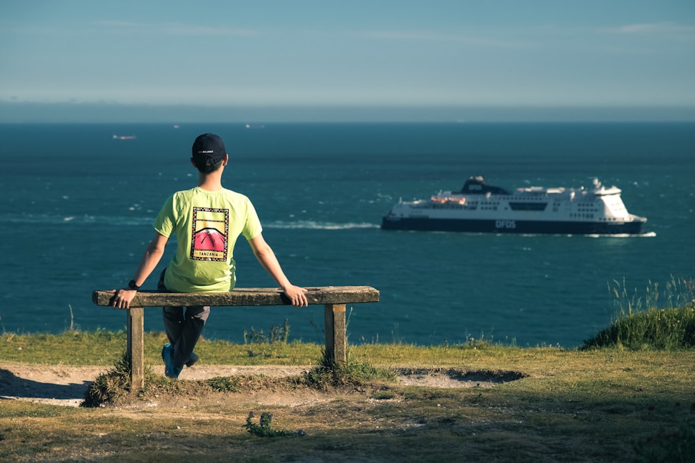 a man sitting on a bench looking out at the ocean