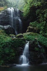 a waterfall in the middle of a lush green forest