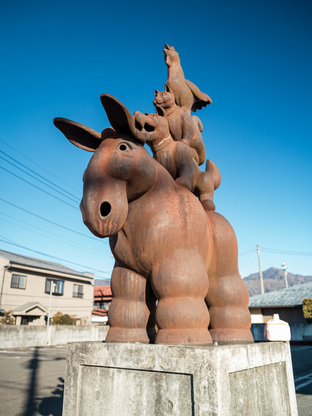 a statue of a horse and a dog riding on top of each other