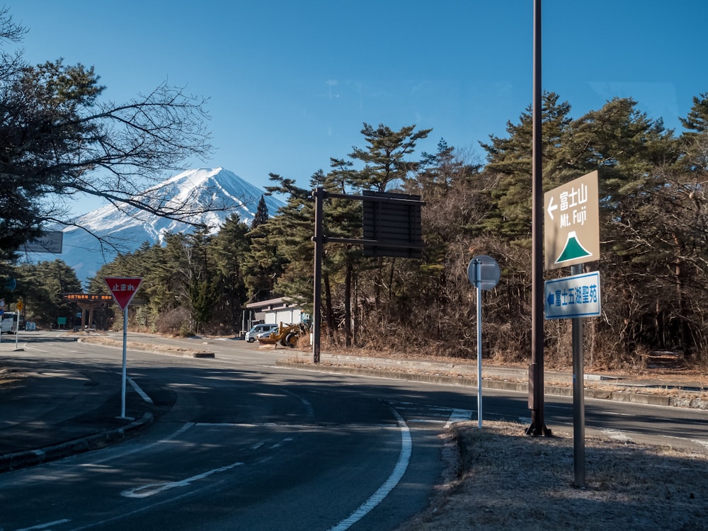 a road with a sign and a mountain in the background