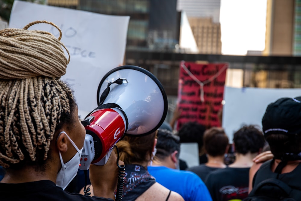 a woman with dreadlocks holding a red and white megaphone