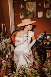 a woman sitting in a chair with a hat on