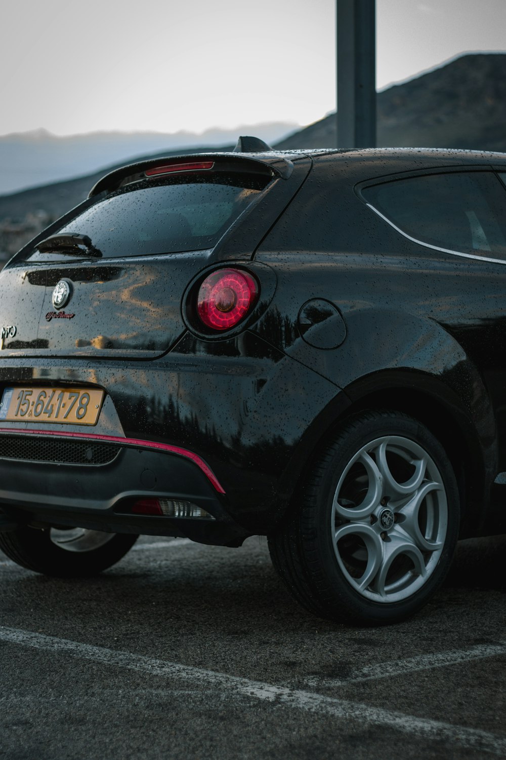 a small black car parked in a parking lot