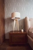 Warmly lit bedroom corner showcasing tailored wooden bedside tables and textured fabrics.