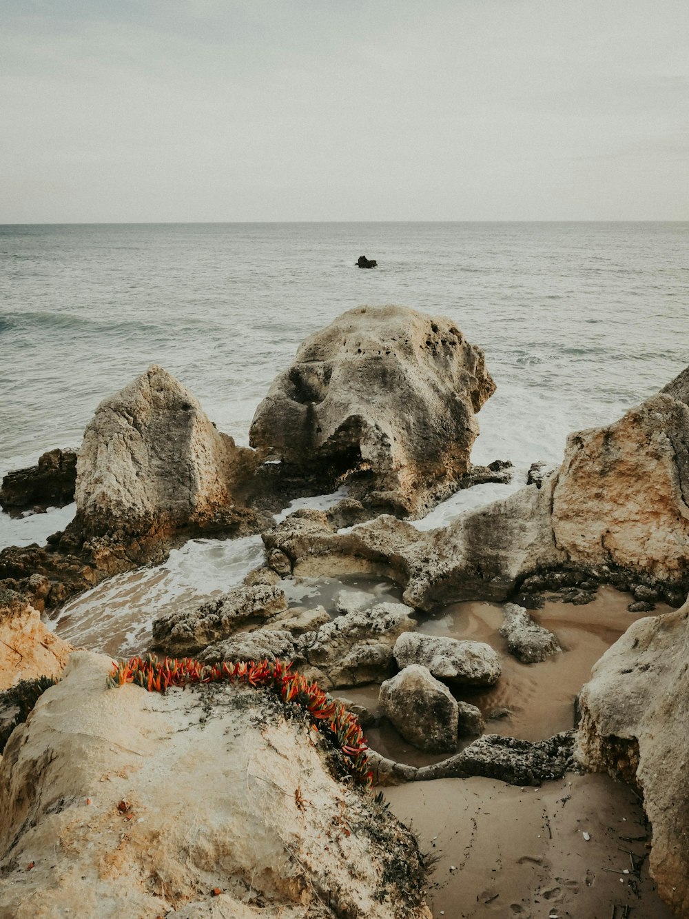 a couple of rocks sitting on top of a beach