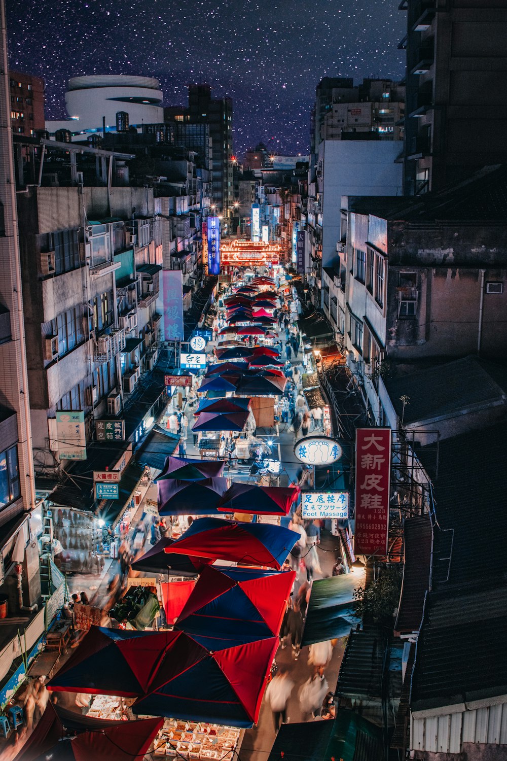 a crowded city street filled with lots of umbrellas