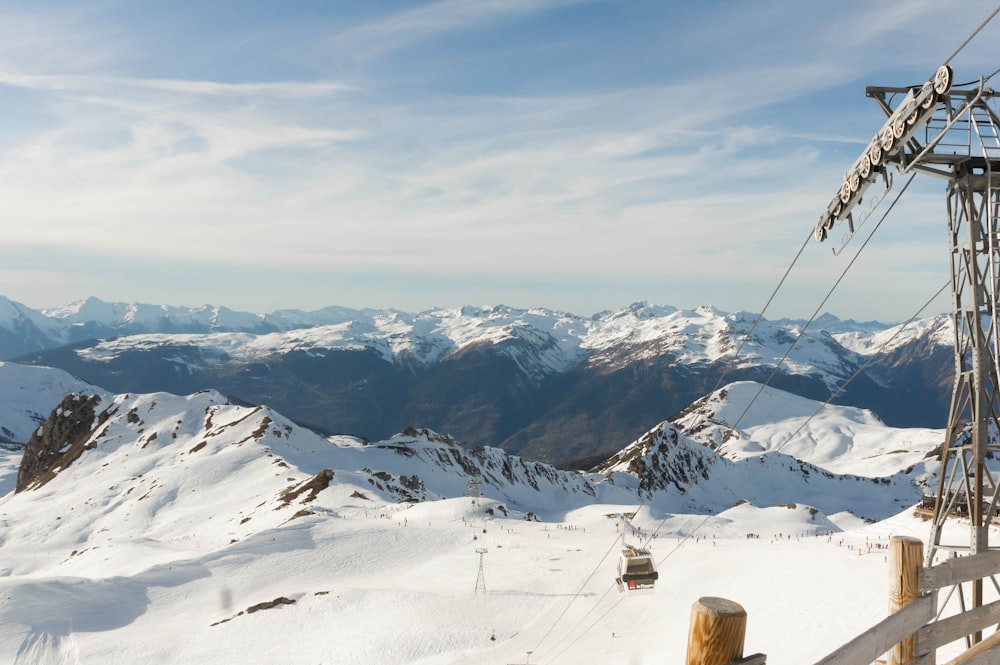 a ski lift on a snowy mountain with mountains in the background