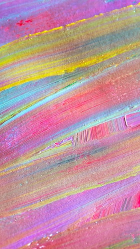 Colorful abstract painting with broad, sweeping brushstrokes in varying shades of pink, yellow, blue, and green. The texture is visible, adding depth and dimension.