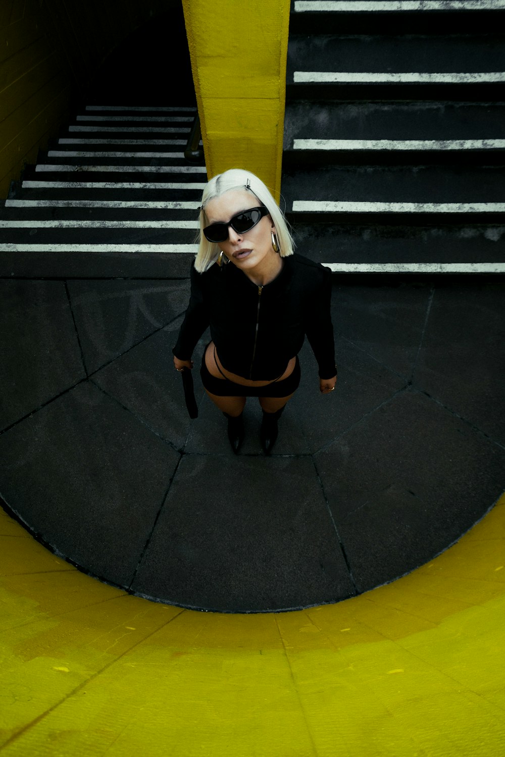 a woman in a black outfit and sunglasses