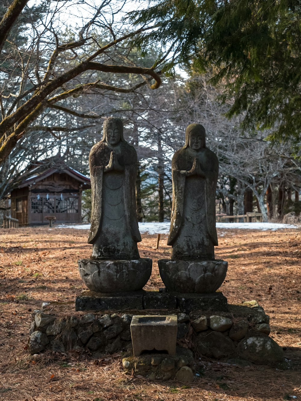 a couple of statues sitting in the middle of a field