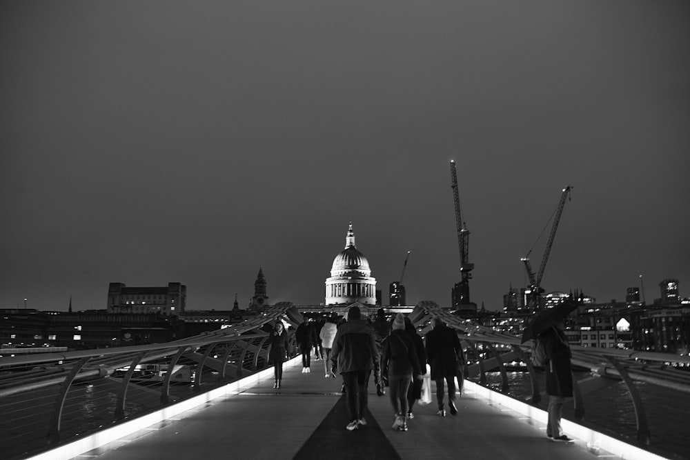 a group of people walking across a bridge