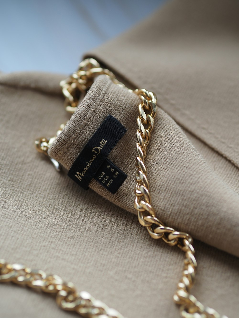 a close up of a gold chain on a jacket