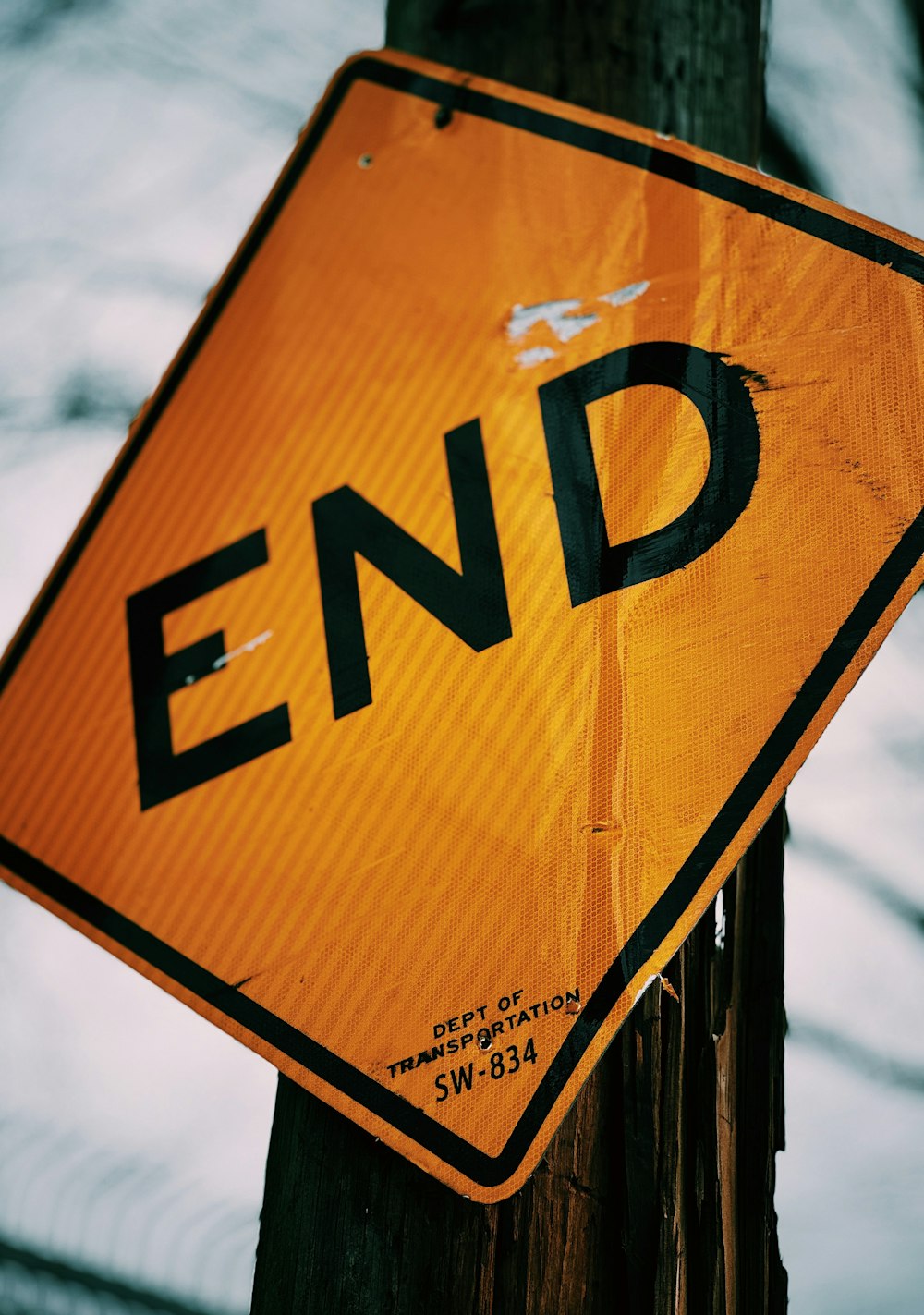 a yellow sign that says end hanging on a telephone pole