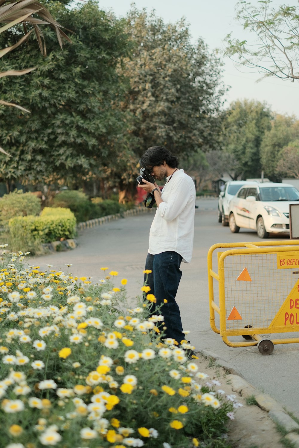 a man standing on the side of a road holding a camera