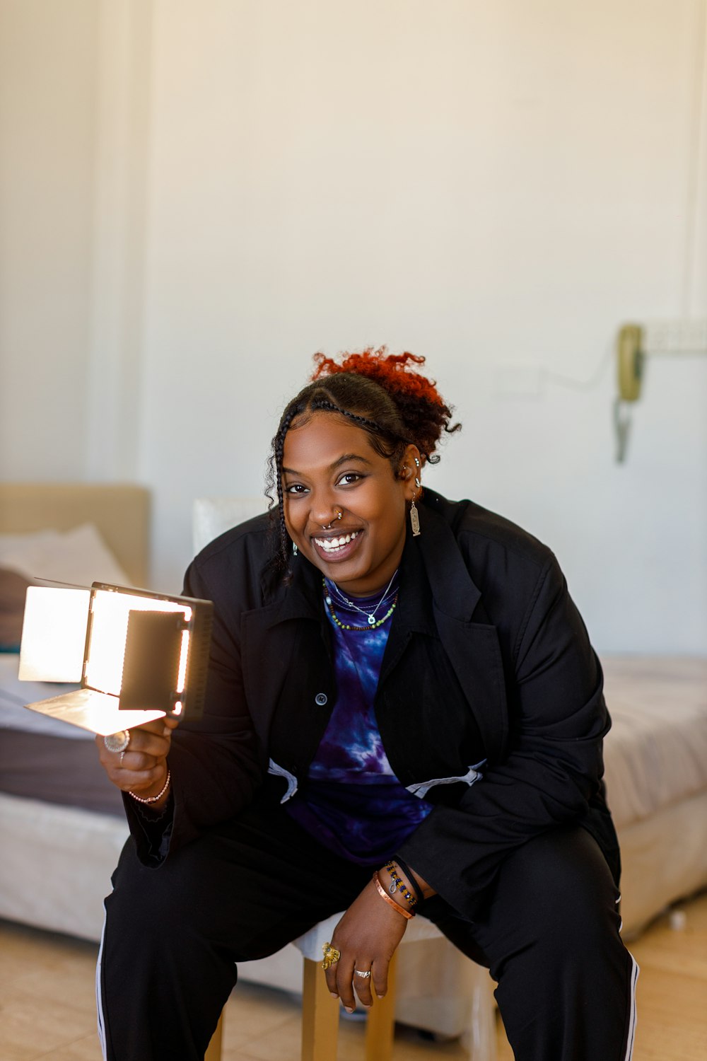 a woman sitting on a stool holding a book