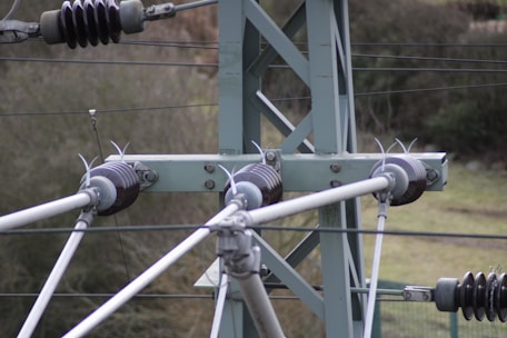 Close-up of a transmission tower being assembled by workers at a fabrication site.