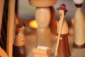 Finished wooden nativity scene displayed on a rustic wooden table with soft lighting.