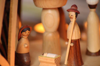 Finished wooden nativity scene displayed on a rustic wooden table with soft lighting.
